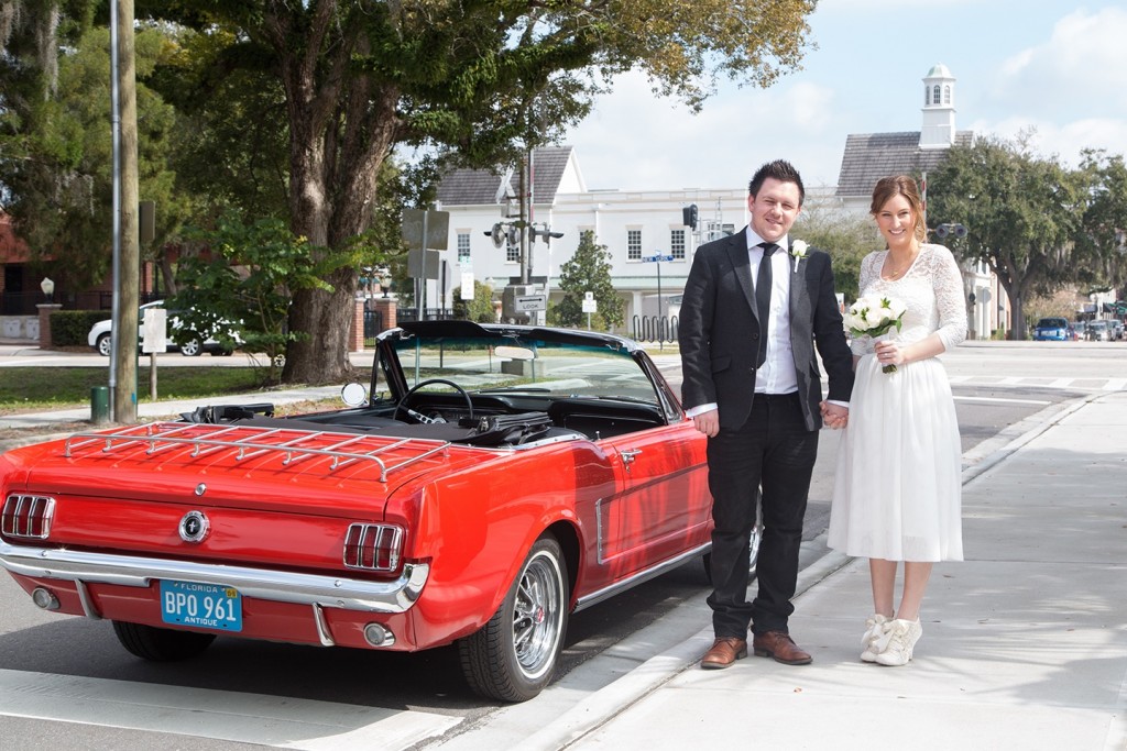 Driving away from their Orlando wedding in style in a bright red Ford Mustang!