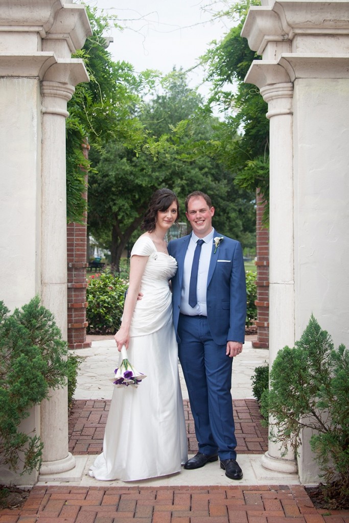 A happy UK couple posing alongside the garden after their Central Florida wedding.